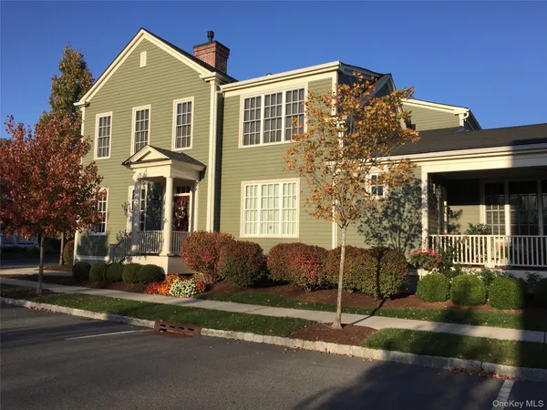 a view of a brick house with a yard next to a road