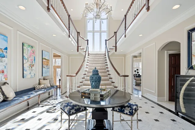 a dining room with wooden floor a chandelier a glass table and chairs