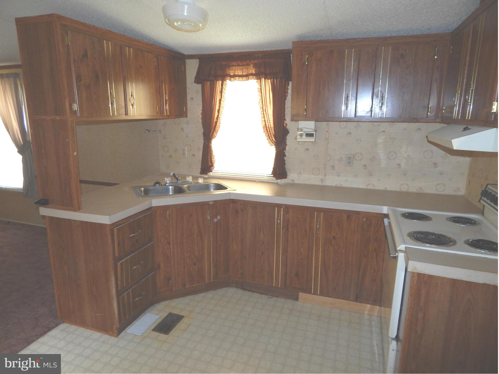 189 Washington Street Inwood, WV 25428 - Photo 9 of 30 a kitchen with a sink window and cabinets