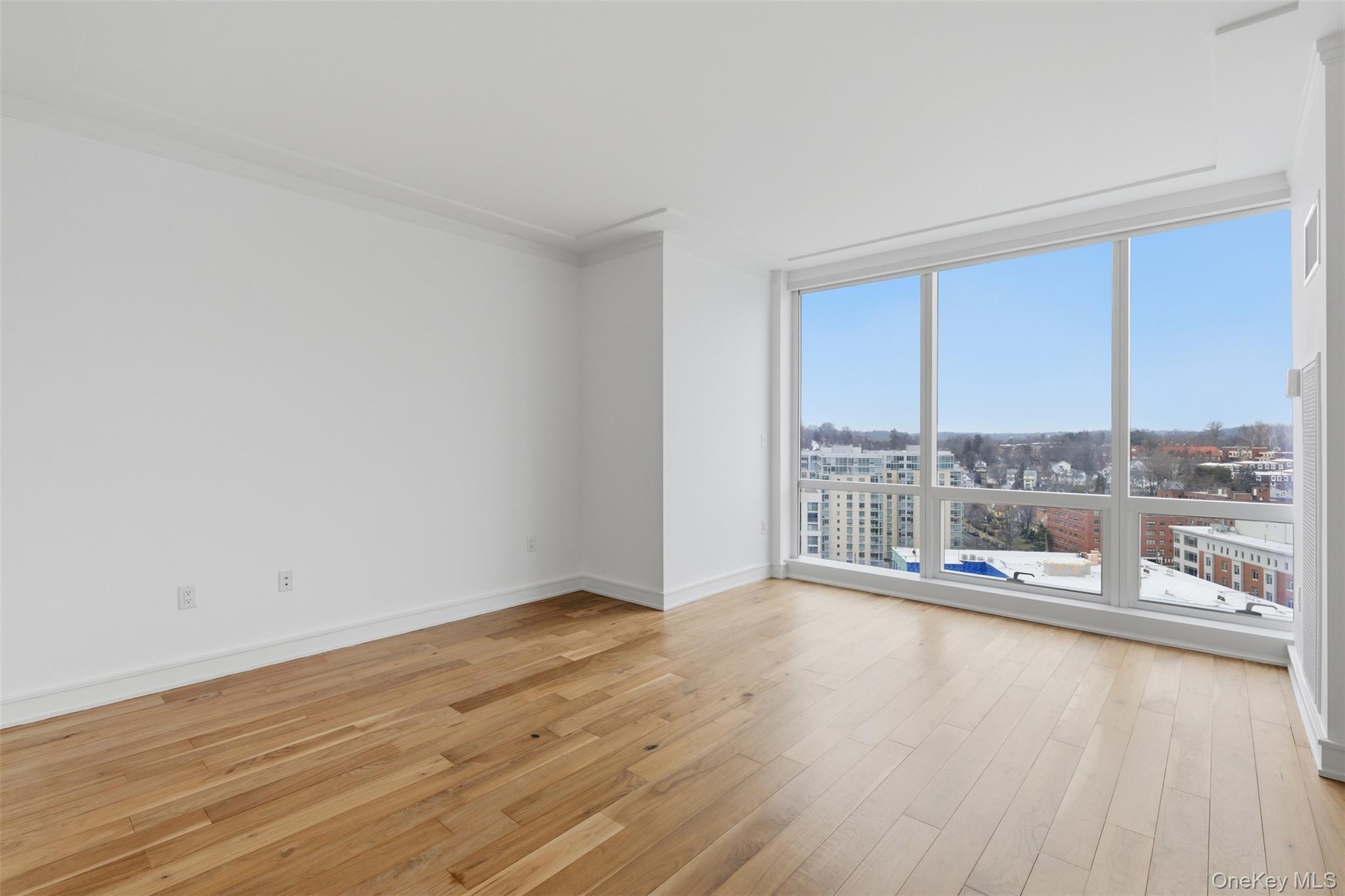 5 Renaissance Square, Unit 16D White Plains, NY 10601 - Photo 16 of 29 wooden floor in an empty room with a window