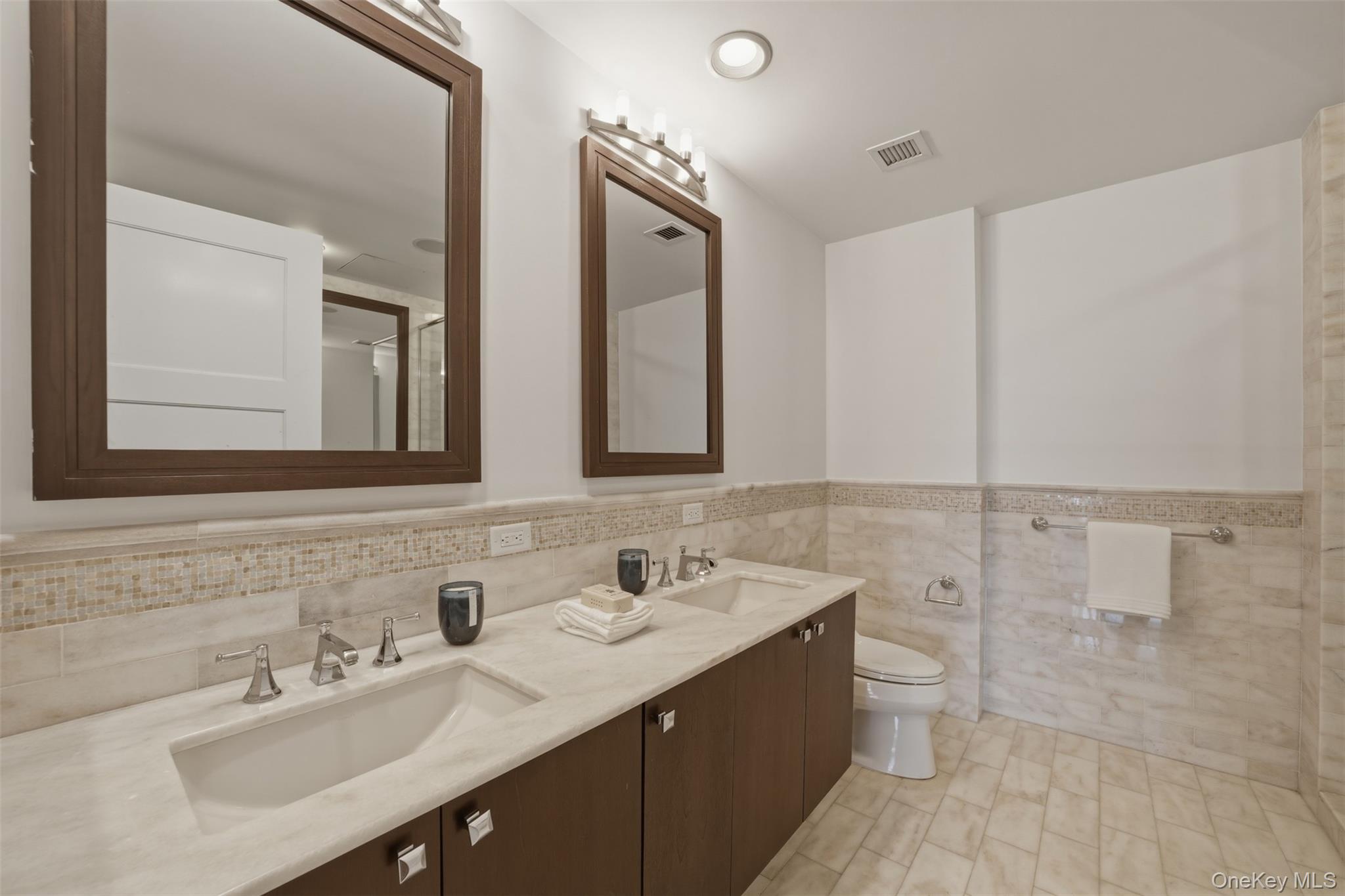 5 Renaissance Square, Unit 16D White Plains, NY 10601 - Photo 16 of 36 a bathroom with a double vanity sink a mirror and a bathtub