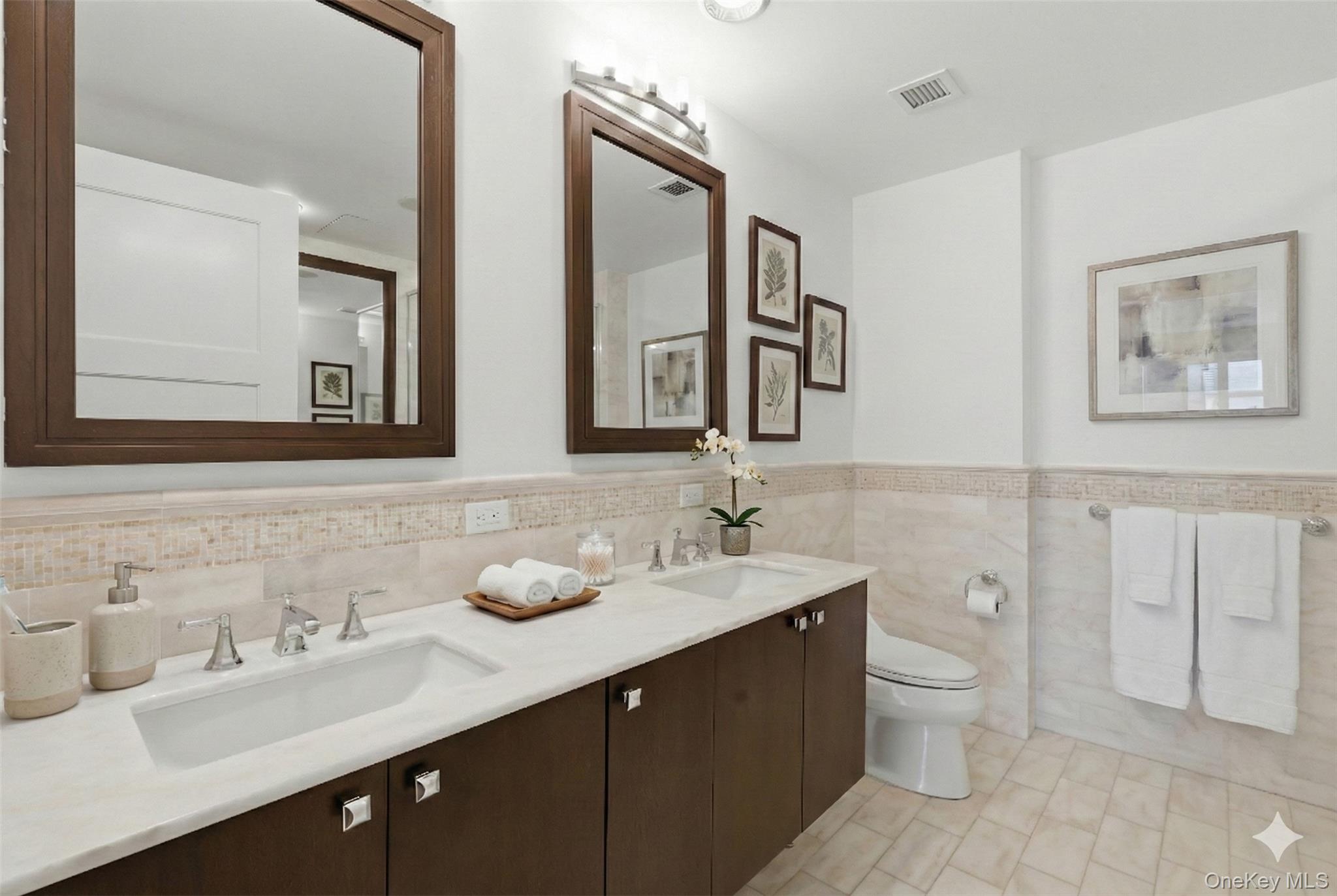 5 Renaissance Square, Unit 16D White Plains, NY 10601 - Photo 19 of 29 a bathroom with double vanity sinks a toilet a mirror and shower
