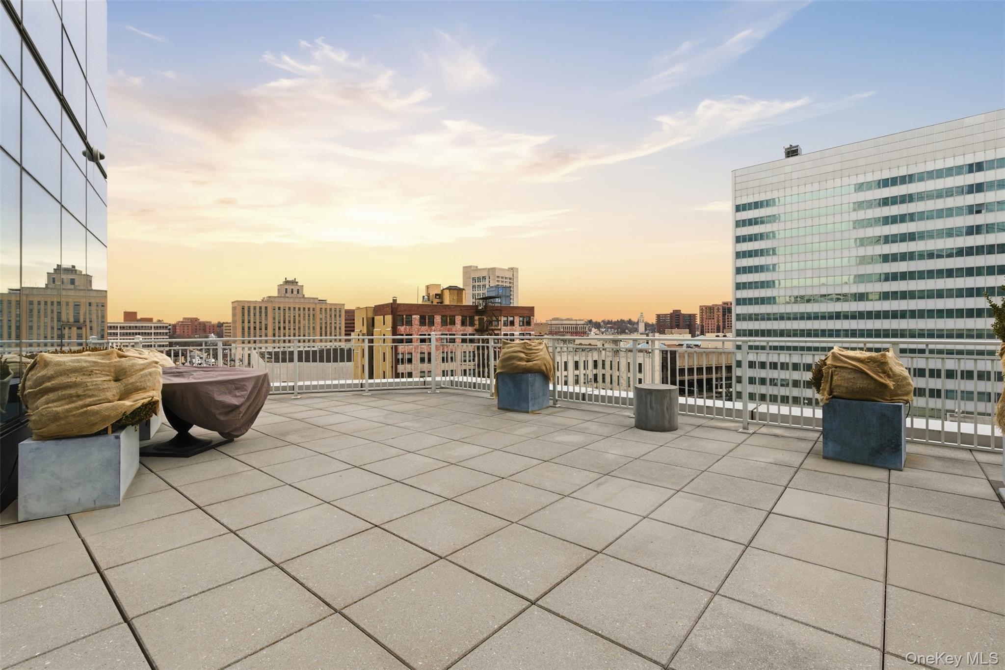 5 Renaissance Square, Unit 16D White Plains, NY 10601 - Photo 33 of 36 a view of roof with potted plants and a bench