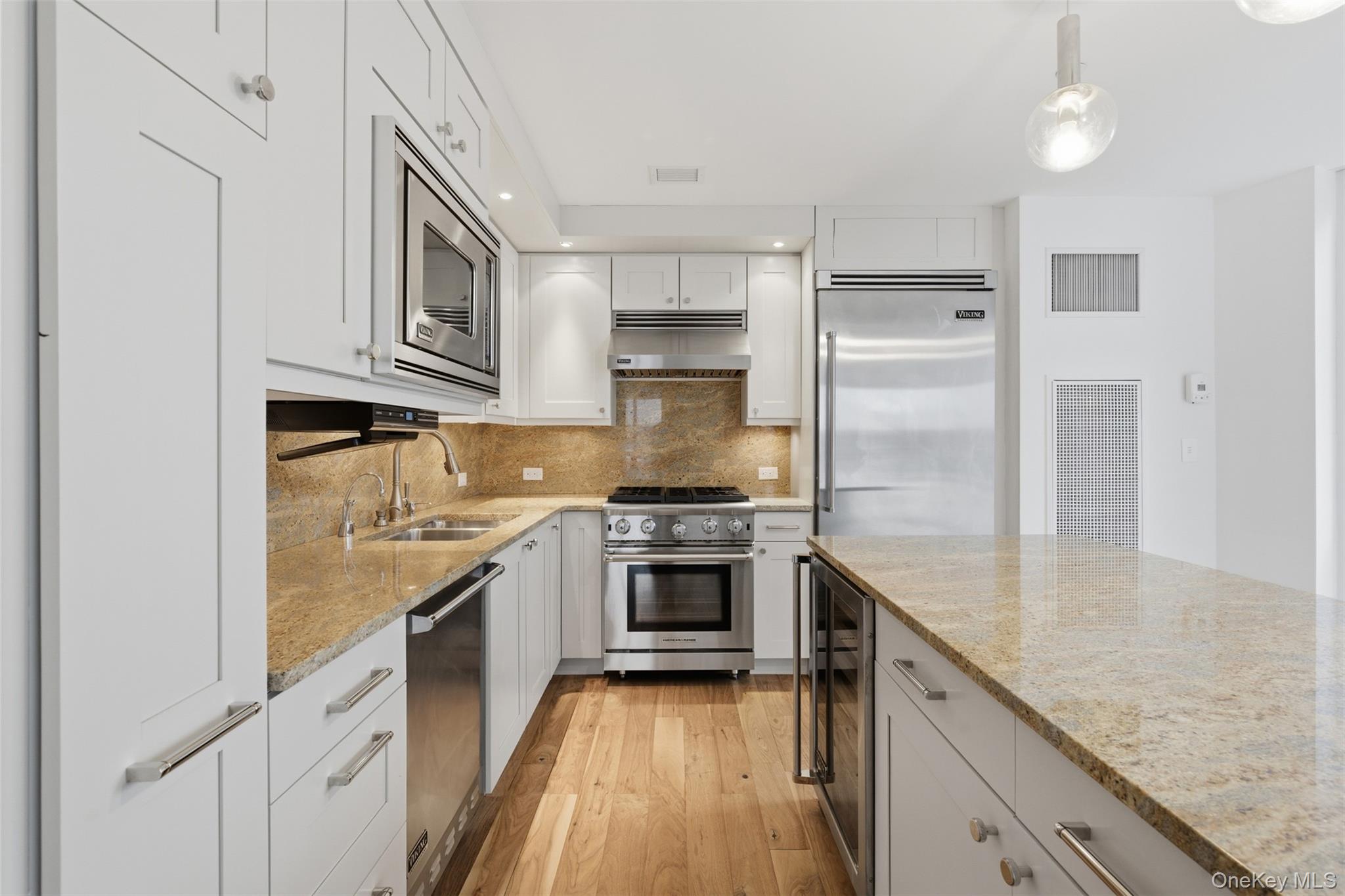 5 Renaissance Square, Unit 16D White Plains, NY 10601 - Photo 9 of 29 a kitchen with stainless steel appliances granite countertop a sink stove and refrigerator