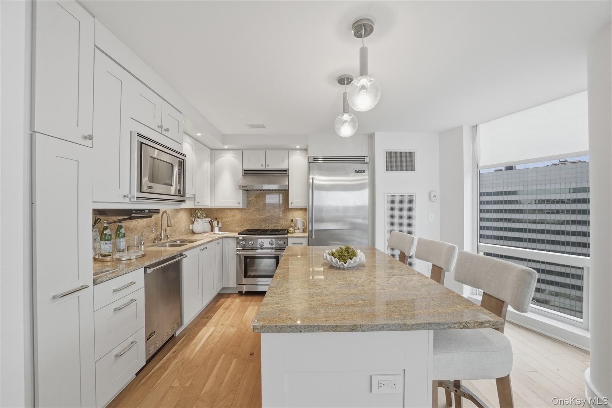 5 Renaissance Square, Unit 16D White Plains, NY 10601 - Photo 10 of 36 a kitchen with stainless steel appliances granite countertop a kitchen island a stove a cabinets a sink and a refrigerator