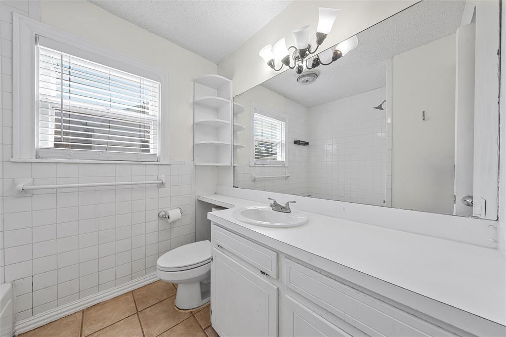 2601 Proctor Avenue Waco, TX 76708 - Photo 16 of 28 a bathroom with a sink a toilet and a mirror