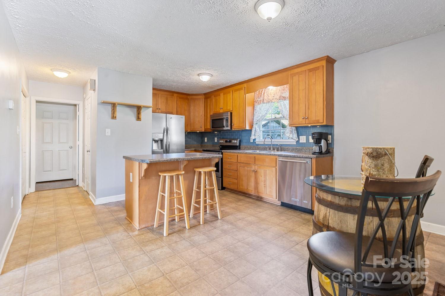 122 Ramsey Road Asheville, NC 28806 - Photo 7 of 19 a living room with furniture a large window and kitchen view