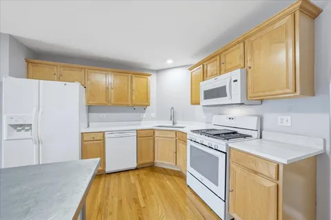 a kitchen with stainless steel appliances granite countertop a stove a sink and a refrigerator