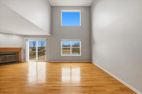 a view of an empty room with glass door and wooden floor