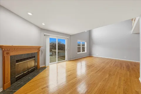 a view of empty room with wooden floor and fireplace
