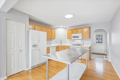 a kitchen with stainless steel appliances granite countertop a refrigerator a stove and a wooden floors