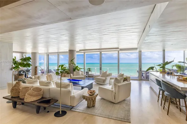 a living room with furniture and floor to ceiling windows