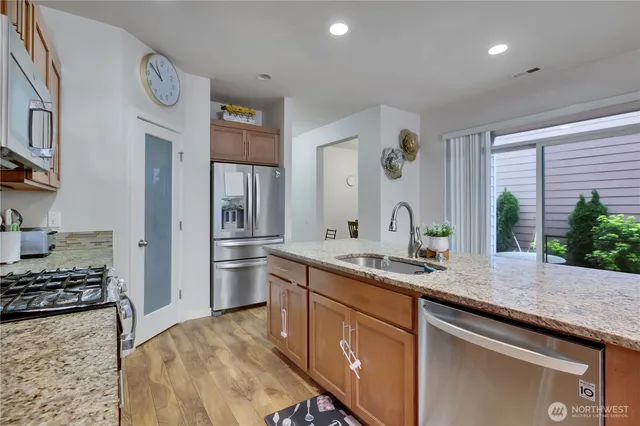 a kitchen with stainless steel appliances granite countertop a sink stove and refrigerator