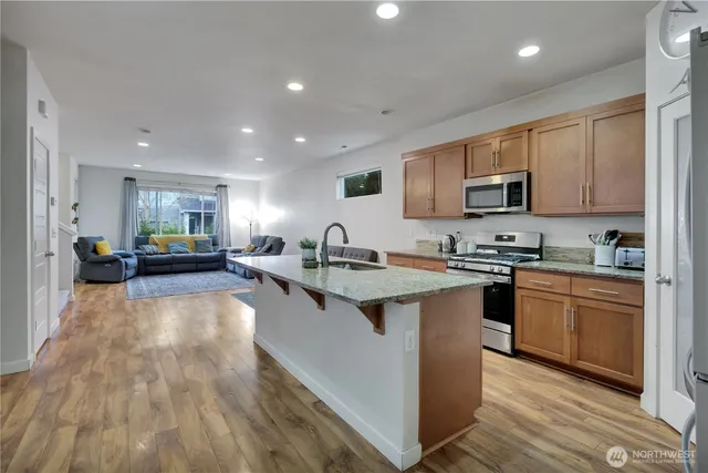 a large kitchen with stainless steel appliances and a sink