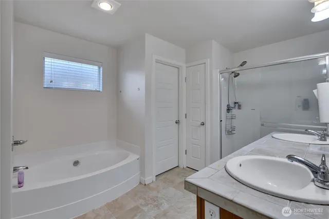 a bathroom with a granite countertop sink a mirror and a bathtub