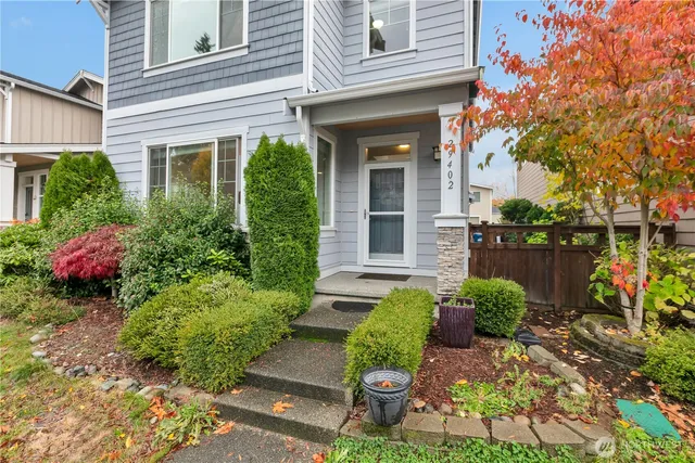 a front view of a house with a yard and potted plants