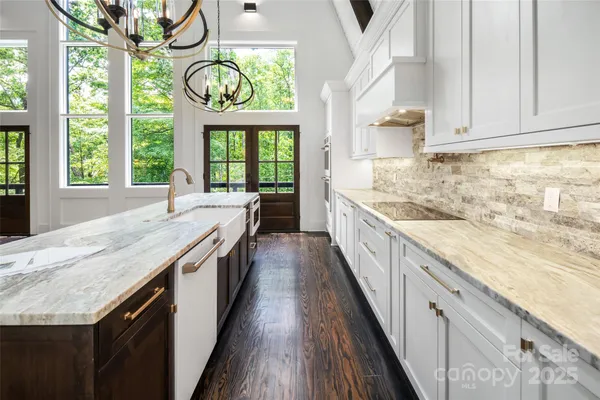 a kitchen with stainless steel appliances granite countertop a stove and a large window