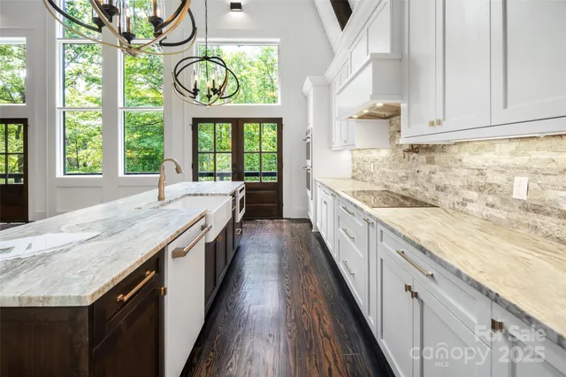 a kitchen with stainless steel appliances granite countertop a stove and a large window