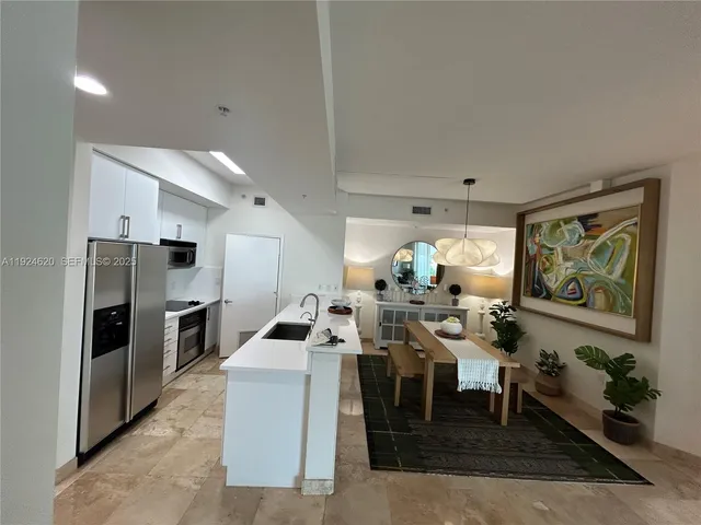 a very nice looking open dining room with kitchen island