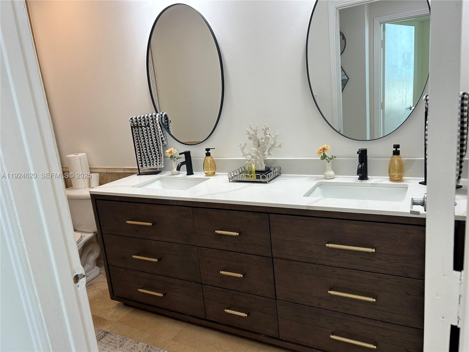9055 Southwest 73rd Court, Unit 809 Miami, FL 33156 - Photo 21 of 47 a bathroom with a double vanity sink and a mirror