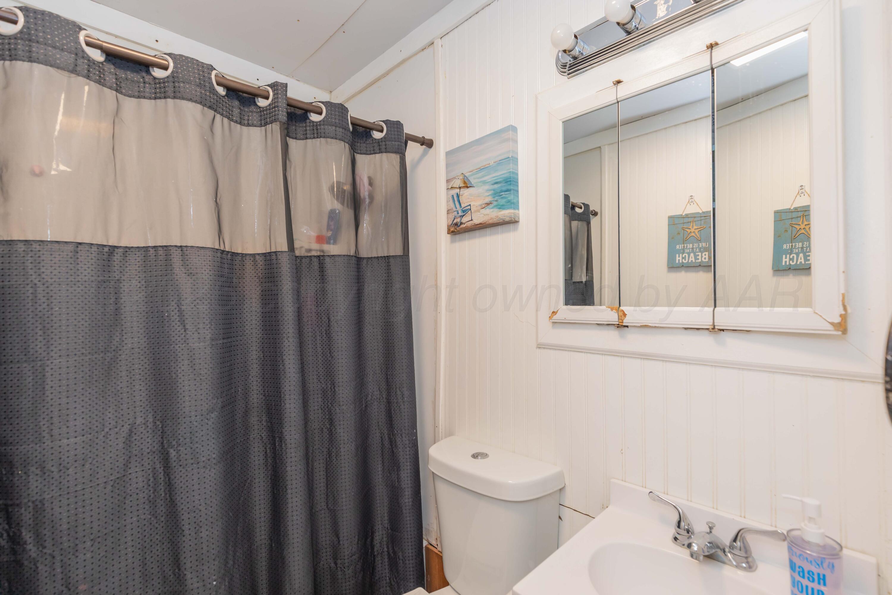 306 Browning Street Amarillo, TX 79104 - Photo 11 of 18 a bathroom with a shower curtain and a sink