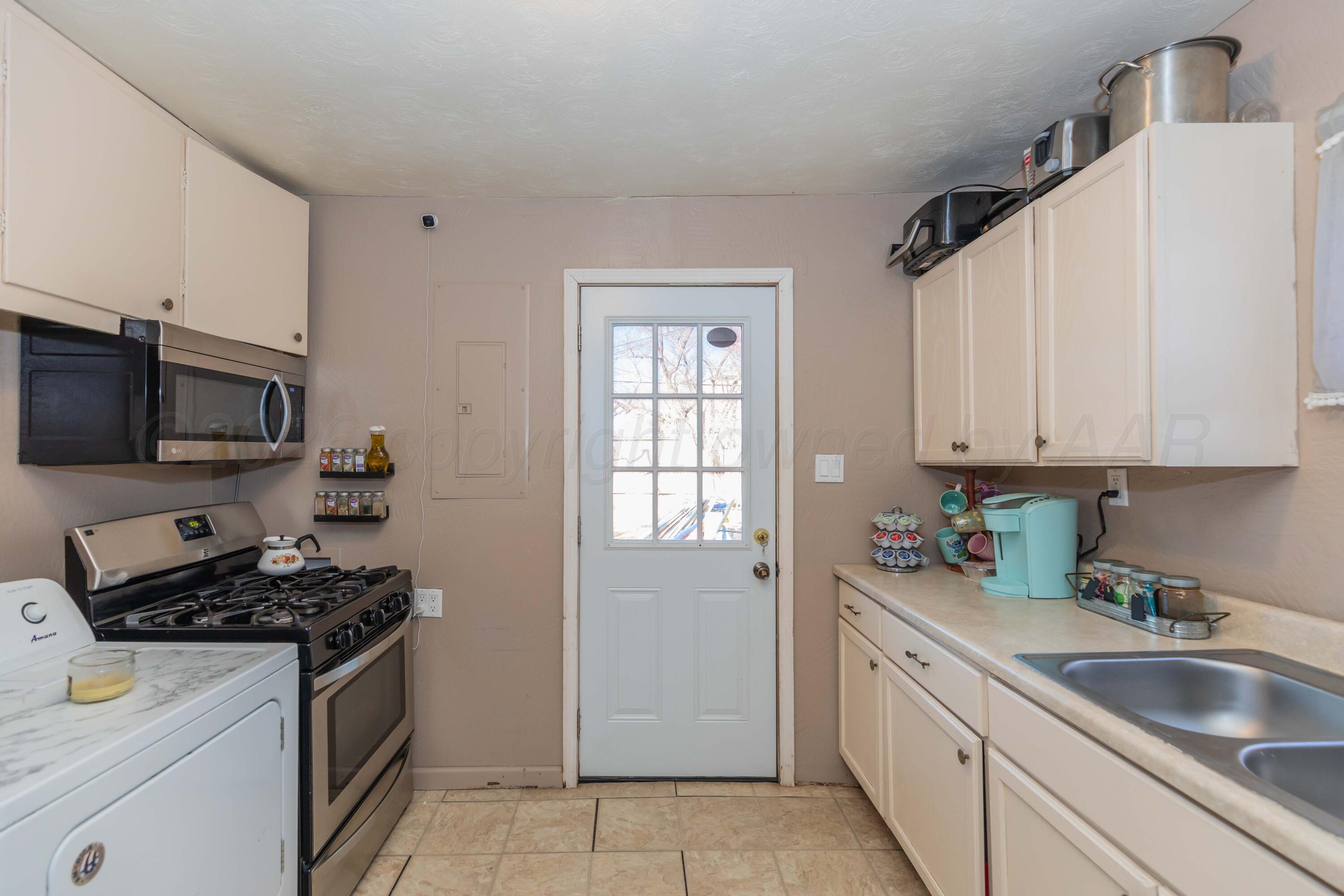 306 Browning Street Amarillo, TX 79104 - Photo 7 of 18 a kitchen with stainless steel appliances granite countertop a sink stove and refrigerator