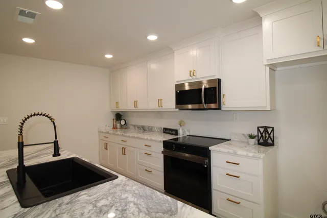 a kitchen with a sink and a stove top oven with wooden floor