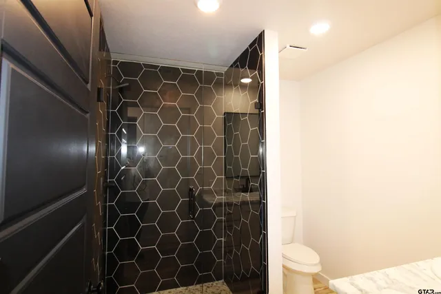 a bathroom with a toilet and a shower