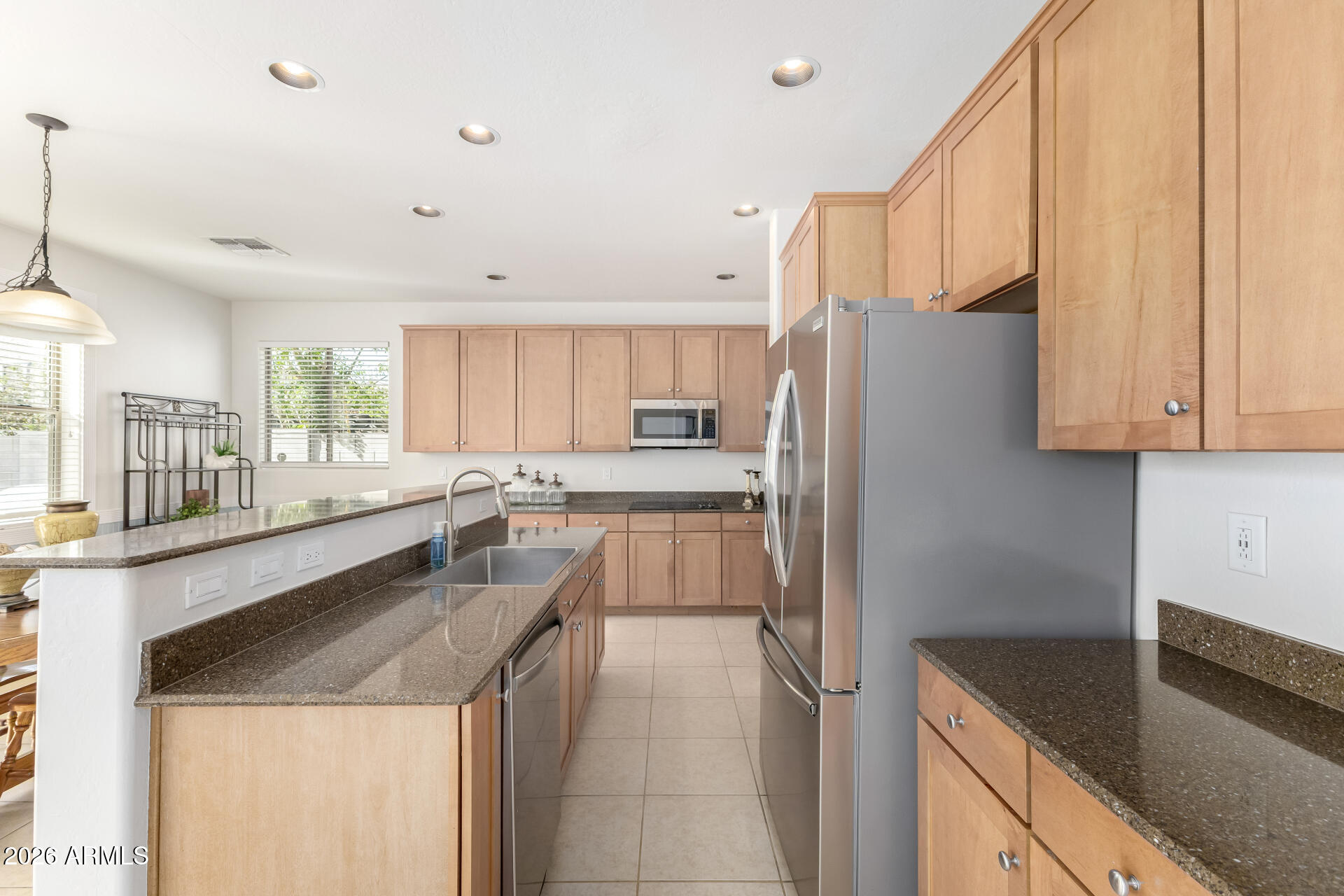 3535 East Terrace Avenue Gilbert, AZ 85234 - Photo 13 of 56 a kitchen with granite countertop a refrigerator and a sink