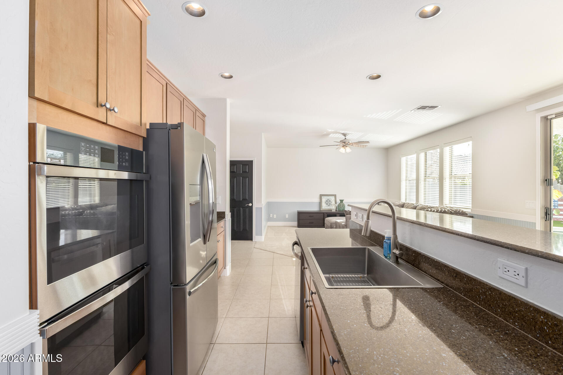 3535 East Terrace Avenue Gilbert, AZ 85234 - Photo 14 of 56 a kitchen with a refrigerator a sink and white cabinets