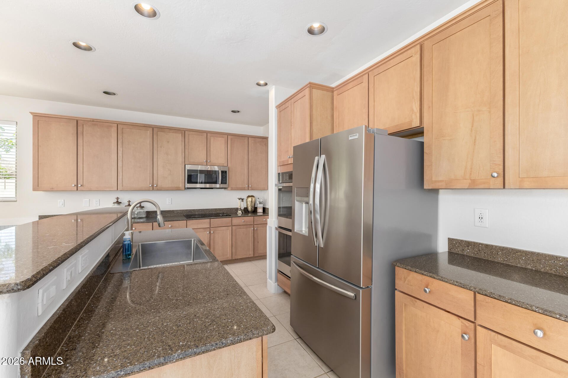 3535 East Terrace Avenue Gilbert, AZ 85234 - Photo 15 of 56 a kitchen with granite countertop a refrigerator stove and sink