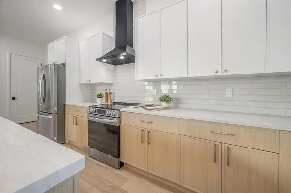 a large white kitchen with a large window