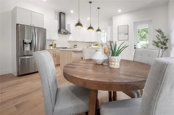 a patio with table and chairs and potted plants