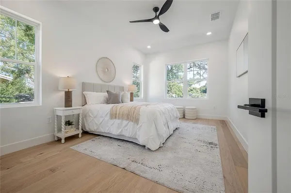 a bedroom with a large bed and ceiling fan