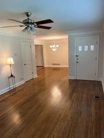 a view of a room with wooden floor and a ceiling fan