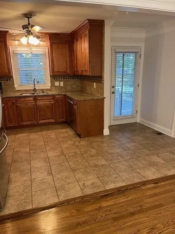 a kitchen with stainless steel appliances granite countertop a sink a stove cabinets and wooden floor