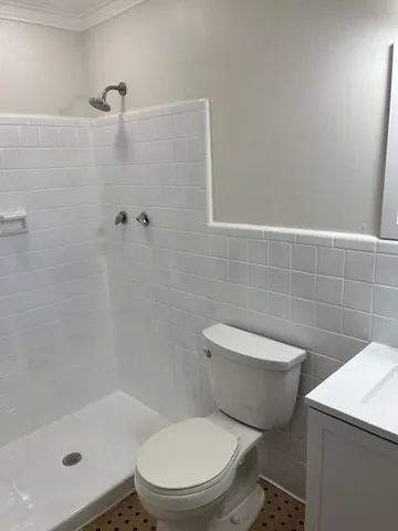 a white toilet sitting next to a bath tub and a shower
