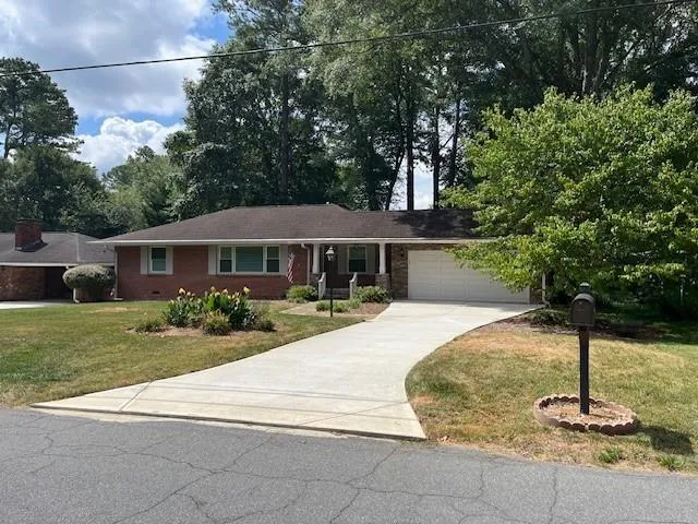 a front view of a house with a yard and trees