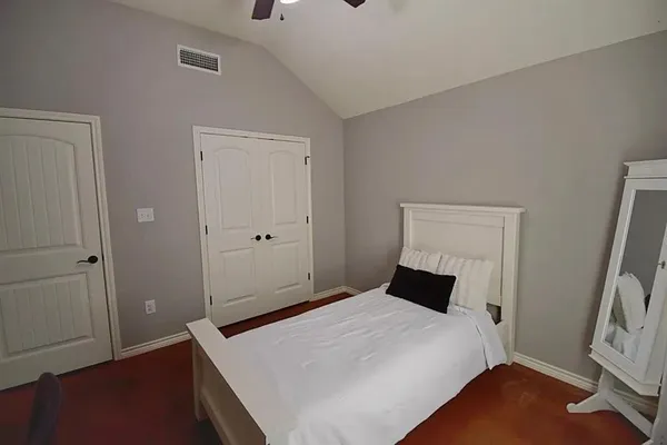 a bedroom with a bed and wooden floor