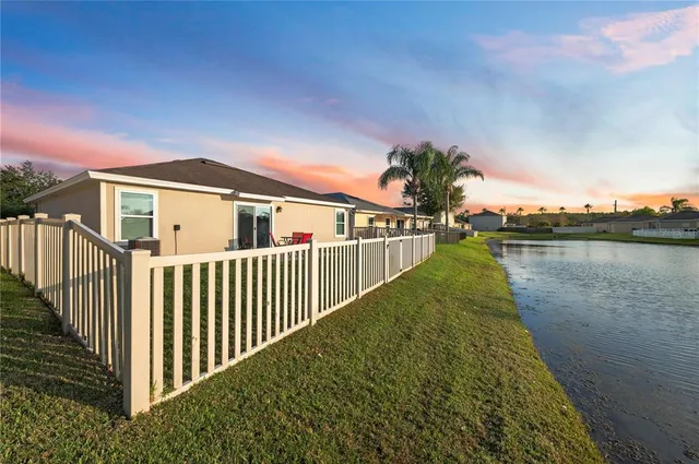 a view of a house with a yard and potted plants