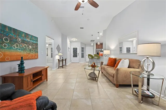 a living room with furniture a chandelier and a flat screen tv
