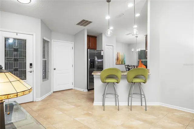 a dining room filled chandelier and kitchen view
