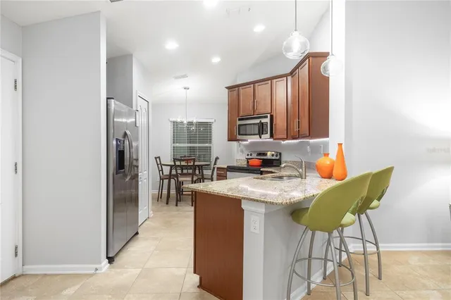 a kitchen with stainless steel appliances granite countertop a refrigerator a stove a sink dishwasher and white cabinets with wooden floor