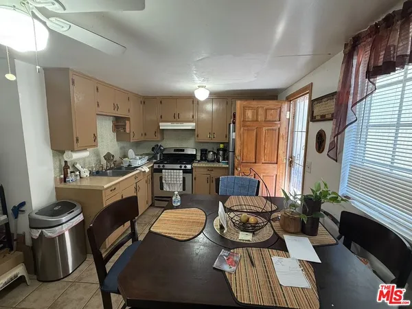 a kitchen with sink refrigerator dining table and chairs
