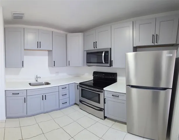 a kitchen with cabinets stainless steel appliances and a sink