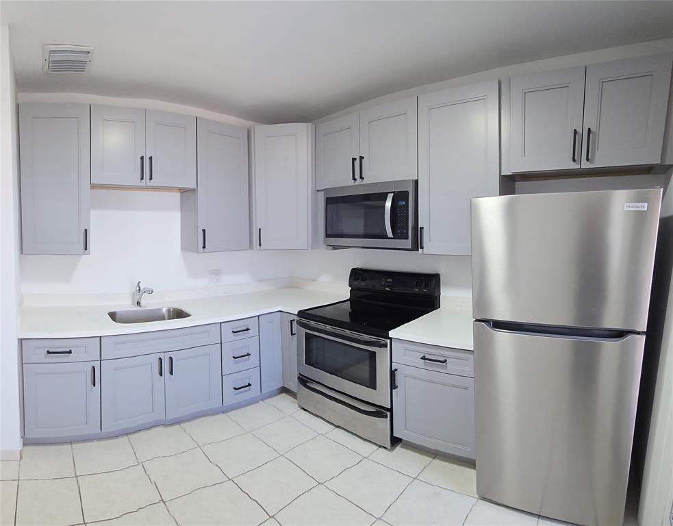 a kitchen with cabinets stainless steel appliances and a sink