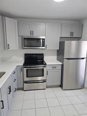 a kitchen with cabinets stainless steel appliances and a counter space