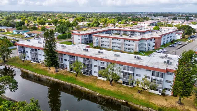 an aerial view of a building with a garden and lake view