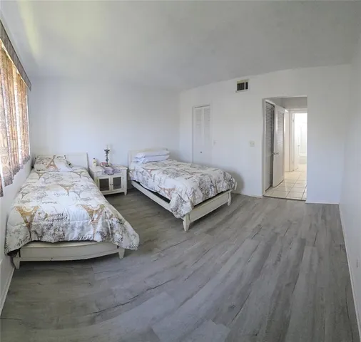 a spacious bedroom with two beds and a window