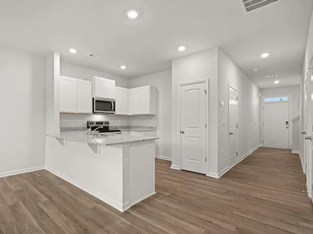 a kitchen with stainless steel appliances granite countertop a sink a stove a microwave and oven